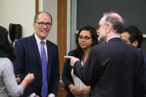 group of people talking to Tom Perez